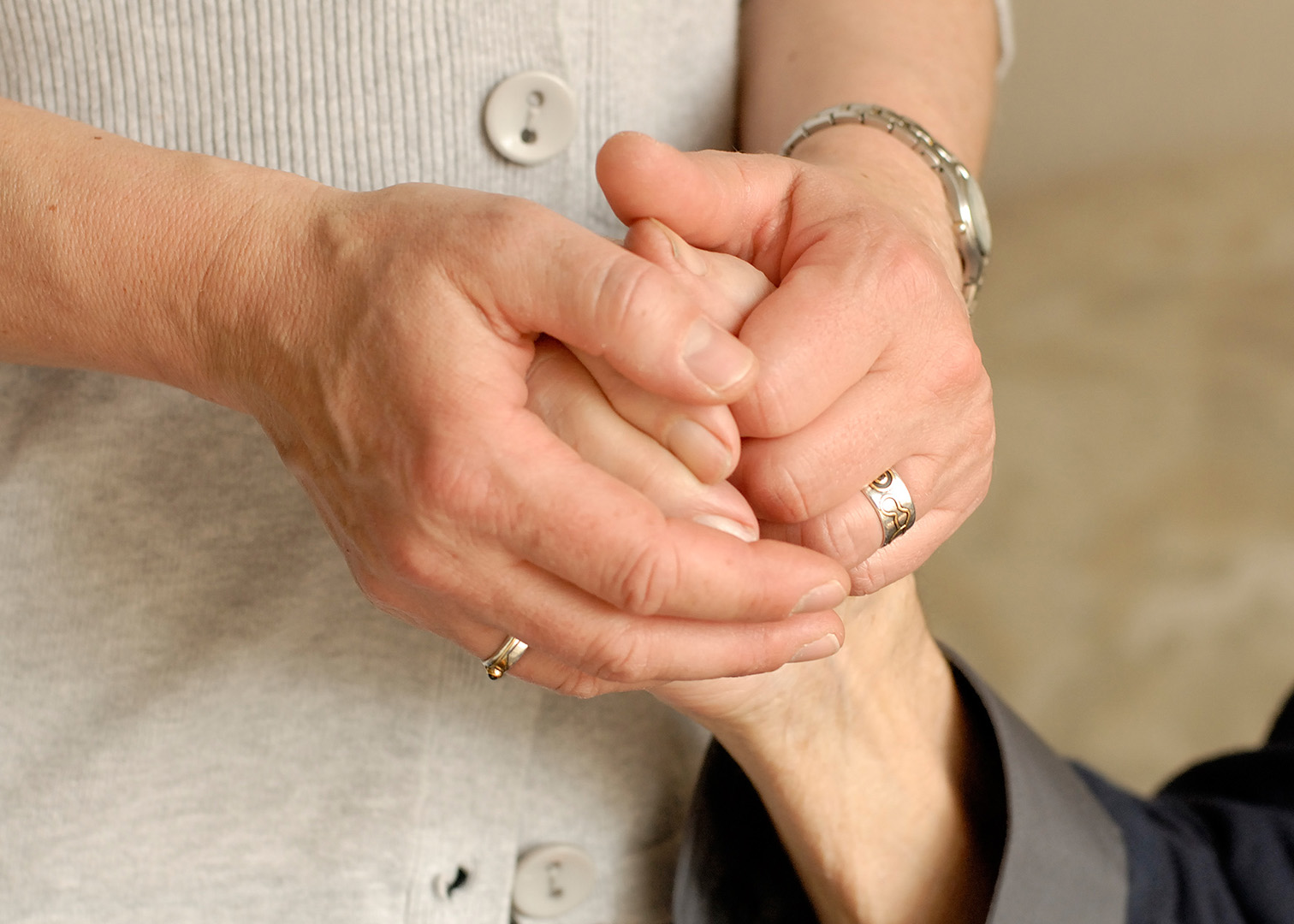 Die Hände einer Pflegerin hält die Hand einer Patientin