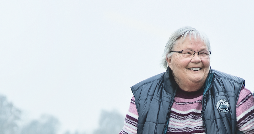 Eine Frau sitzt und lächelt in die Kamera