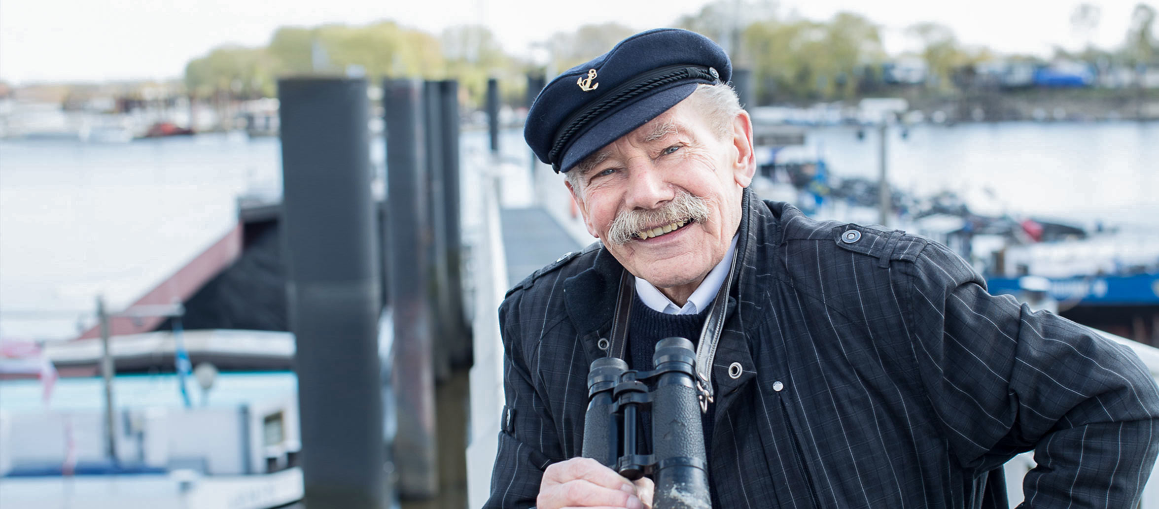 Älterer Mann mit Elbsegler lächelt in die Kamera